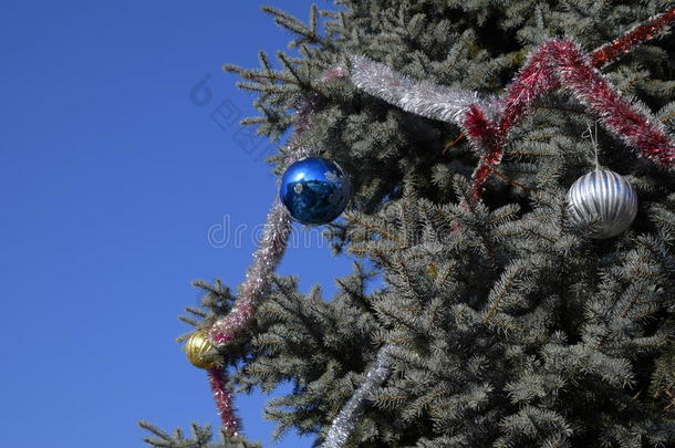 装饰新年树。 站在露天的圣诞树上的金属罐和玩具、球和其他装饰品