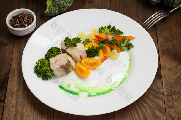 蒸蔬菜煮鲈鱼-完全健康的一餐。木质背景。俯视图。特写镜头