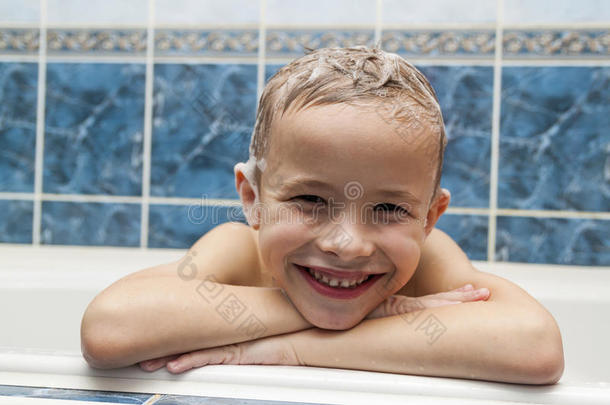 可爱的小男孩用洗发水肥皂在洗头发上洗澡。 CL