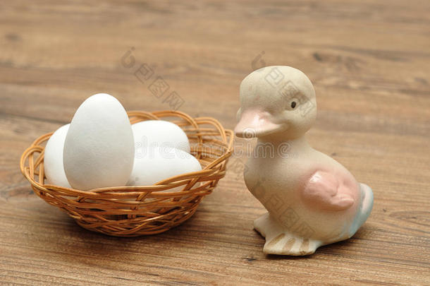 一种陶瓷鸭子，篮子里装满了白色复活节彩蛋