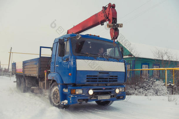 晴天白雪覆盖的冬季村庄的建筑卡车