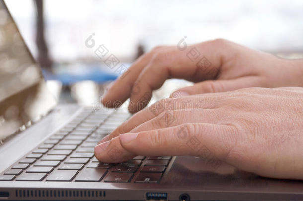 双手在笔记本电脑键盘上打字