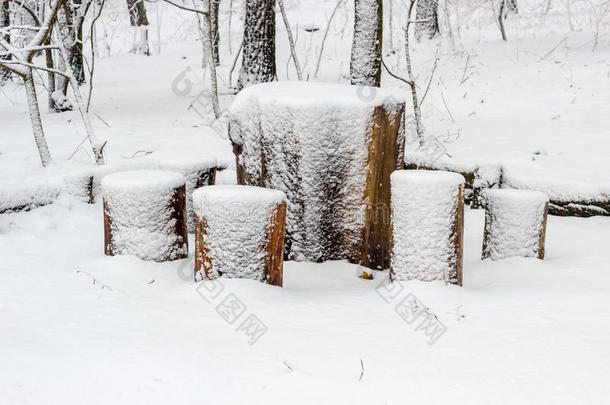 用木制原木制成的花园家具覆盖着雪