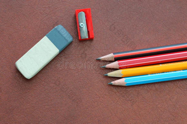 橡皮擦，在棕色皮革背景上写铅笔和卷笔刀