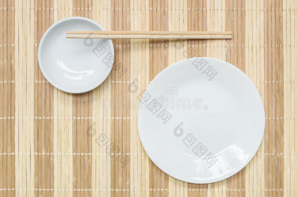 特写白色陶瓷<strong>盘子</strong>和粉笔与木<strong>筷子</strong>在木垫纹理背景在餐桌上的顶部视图