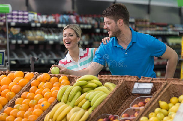 一对夫妇在超市买水果和蔬菜