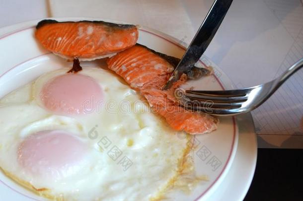 煎鸡蛋和鲑<strong>鱼</strong>放在白色盘子里。 <strong>美味</strong>的有机<strong>早餐</strong>。