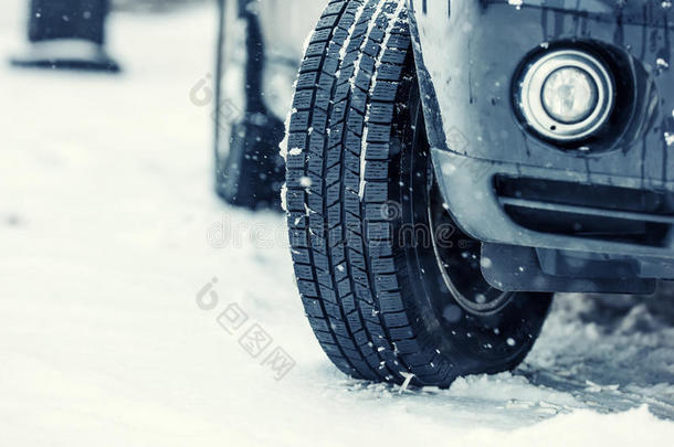 在一条下雪的路上特写汽车轮胎。路上的暴风雪