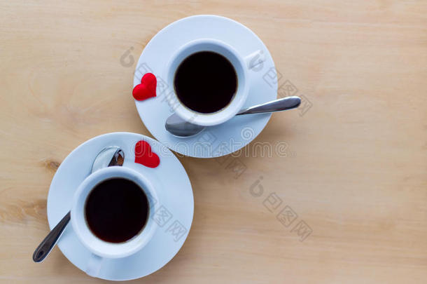 几杯咖啡，用红心装饰在木桌上。
