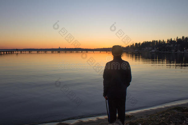 一个人的剪影，看着一个冬天的日落在胡安妮塔湾公园，柯克兰，华盛顿
