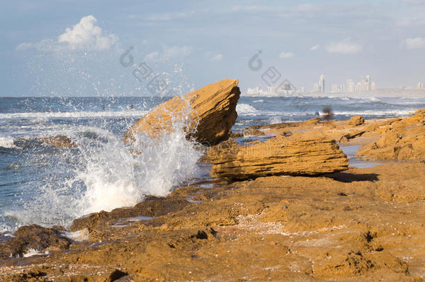 海滩海浪飞溅城市景观建筑石岸。