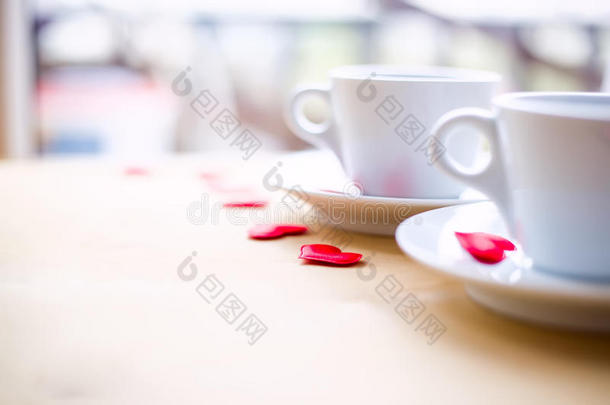 几个杯子，用<strong>红心装饰</strong>在木桌上。
