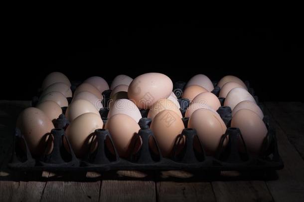 在黑色背景上的木板上的鸡蛋