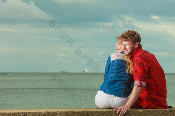 一对夫妇坐在海边拥抱