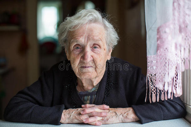老年妇女肖像，坐在房子里。 养老金领取者。