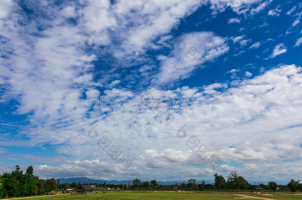 多云的蓝天，草地和远山