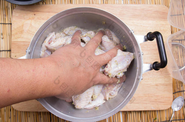 厨师把<strong>调料</strong>混合到锅里的鸡翅上