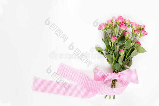 新鲜的粉红色小玫瑰和粉红色格子丝带