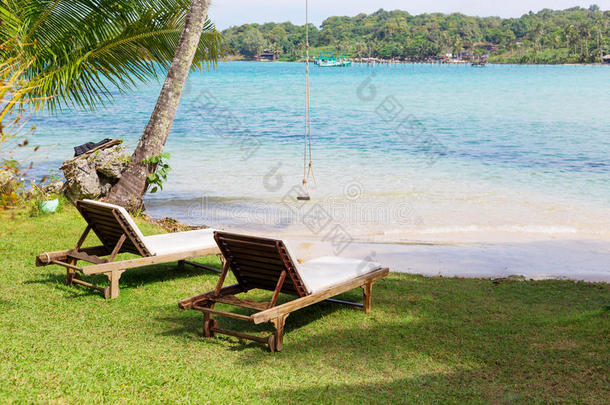 白色沙滩上的沙滩椅子，蓝天和阳光