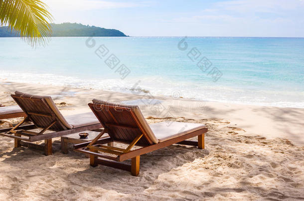 白色沙滩上的沙滩椅子，蓝天和阳光