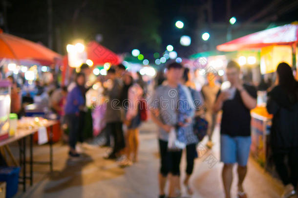 模糊的照片，人们走在街上的夜场。