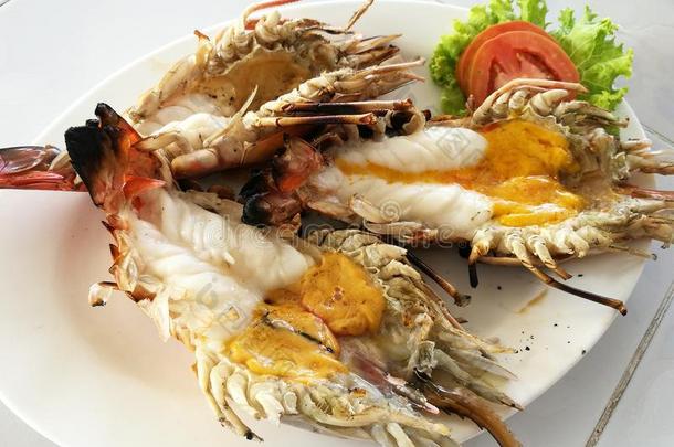 美味的烤巨型淡水河虾与融化的橙色头油，在泰国海鲜餐厅