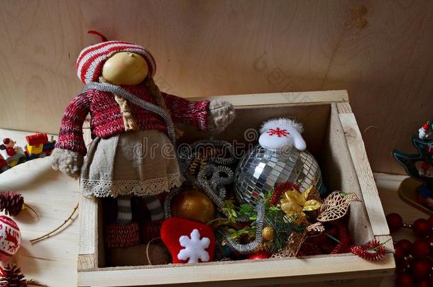 一个穿着圣诞服装的洋娃娃和一盒装饰品