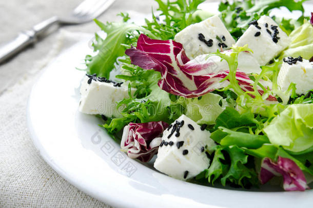 绿色沙拉，菠菜，羊肚菌，花生米，费塔奶酪和黑芝麻在蓝色的木制背景