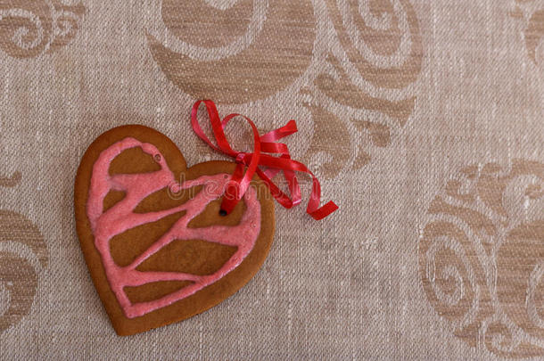巧克力姜饼饼干心形与红色和粉红色的糖霜和红色<strong>丝带</strong>下<strong>彩色</strong>织物