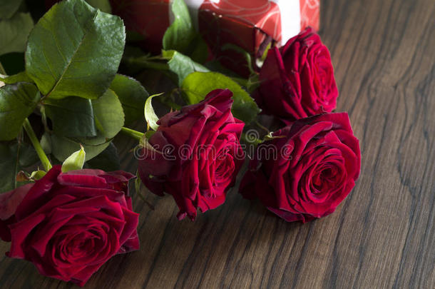 带有白色丝带和红色玫瑰花束的礼品盒