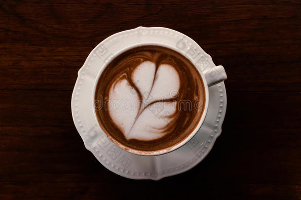 特写杯热咖啡郁金香拿铁艺术在木桌上，复古