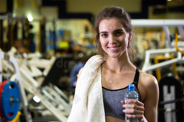 漂亮的年轻运动女人。 健身女孩训练在体育俱乐部与运动设备。