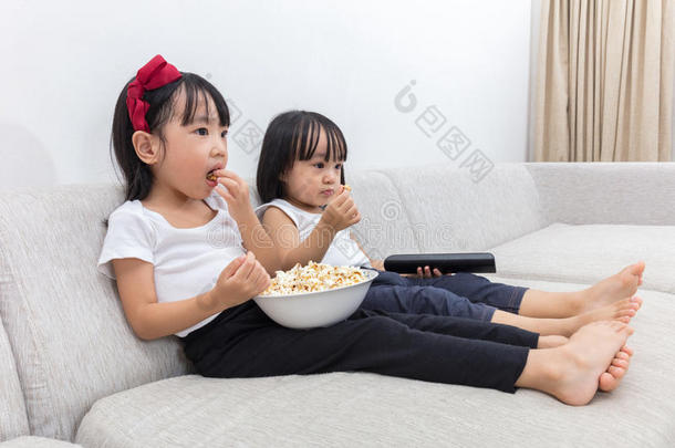 亚洲的中国小姐妹在沙发上吃爆米花