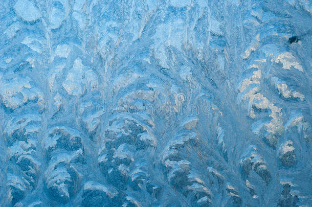 美丽的冬霜和玻璃上的冰卷。 这是霜状图案的窗户。 图案a，特写。 在