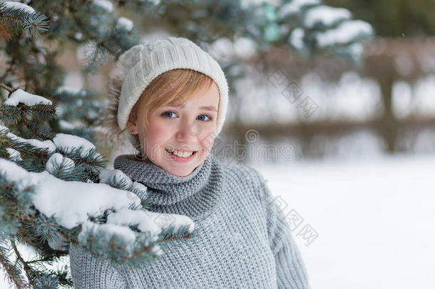 冬天雪林里戴着白色帽子和手套的漂亮女孩