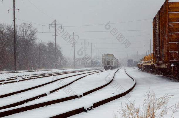 在冬天下雪的时候，货运列车在铁路轨道上运行的后视镜