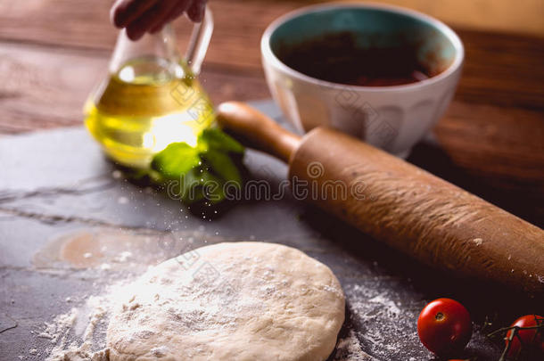 在木桌上用面粉做面团，准备自制比萨饼