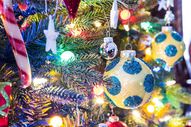 <strong>圣诞</strong>树装饰品。黄色，有光泽的表面，有蓝色圆圈的球体，发光，周围有明亮的五<strong>彩灯</strong>光。