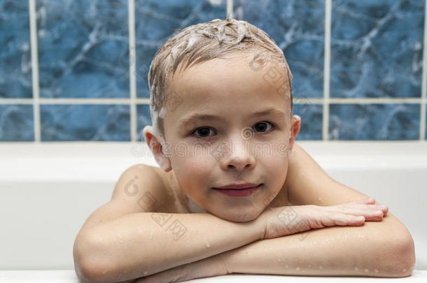 可爱的小男孩用洗发<strong>水肥</strong>皂在洗头发上洗澡。 CL
