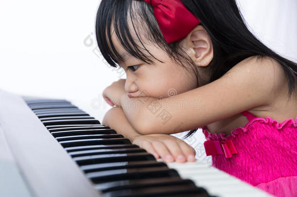 无聊的亚洲中国小女孩玩电动<strong>钢琴</strong>键盘