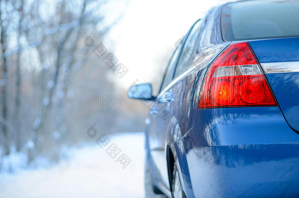 冬天雪路上的蓝色汽车。 关闭后视镜。 旅行和<strong>驾驶安全</strong>概念。