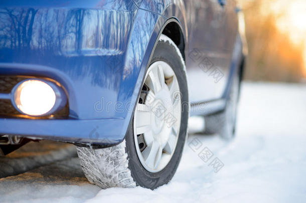 雪路上有冬天轮胎的蓝色汽车。 开车安全。