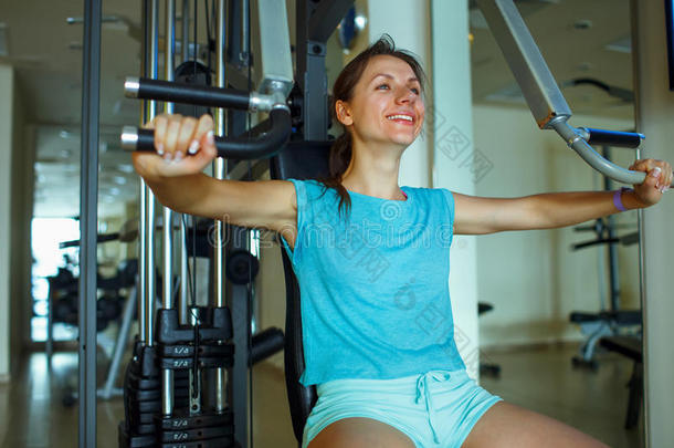 运动妇女在健身房锻炼器械