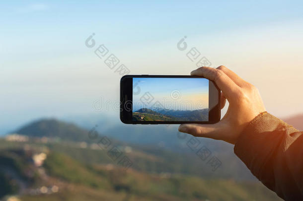特写手使用手机拍照山景在m