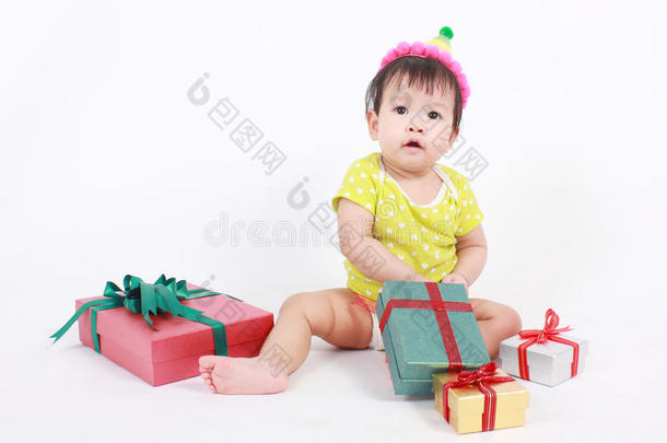 宝贝笑着戴着派对帽，小宝贝用一堆礼品盒庆祝。