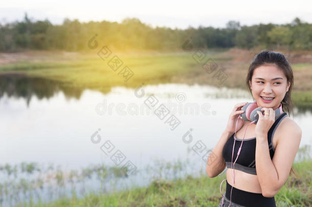 健身，<strong>运动</strong>和健康的生活方式概念-快乐的十几岁的女人或带<strong>耳机</strong>的女<strong>运动</strong>员户外