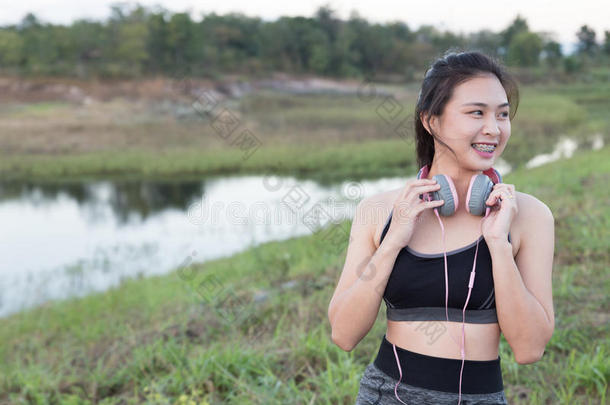 健身，运动和健康的生活方式概念-快乐的十几岁的女<strong>人</strong>或<strong>带耳机</strong>的女运动员户外