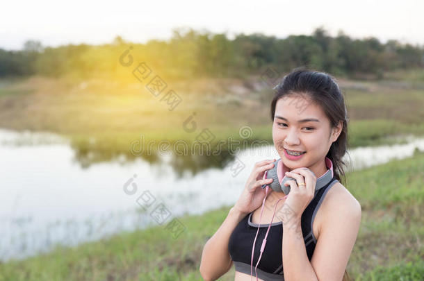 健身，运动和健康的生活方式概念-快乐的十几岁的女人或带耳机的女运动员户外