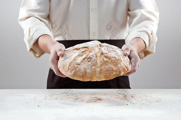 面包师手里拿着乡村有机面包