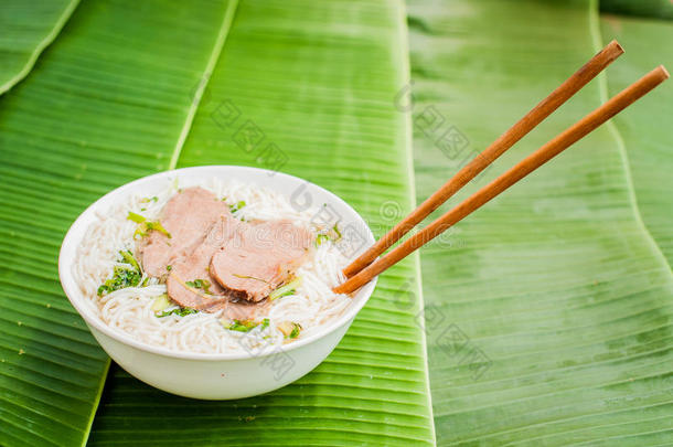 香蕉叶背景上的一碗传统越南牛肉汤。